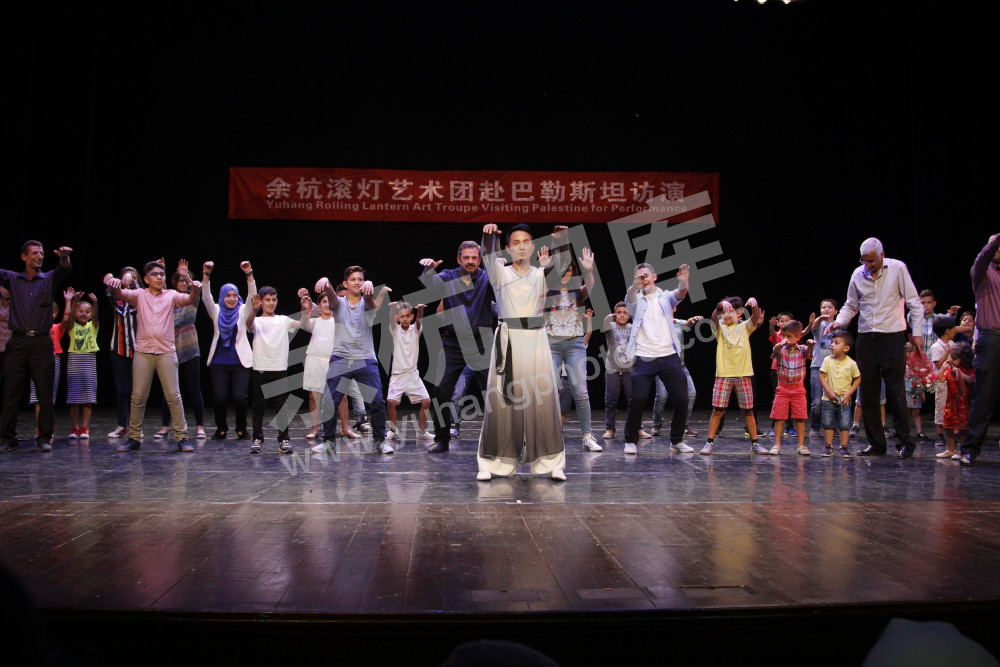 余杭滚灯艺术团赴巴勒斯坦访演，图为滚灯艺术团演员在演出结束后教观众打太极