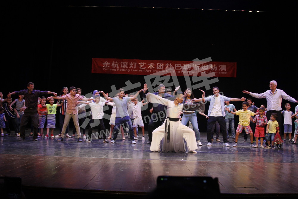 余杭滚灯艺术团在巴勒斯坦演出，观众上台参与太极互动 